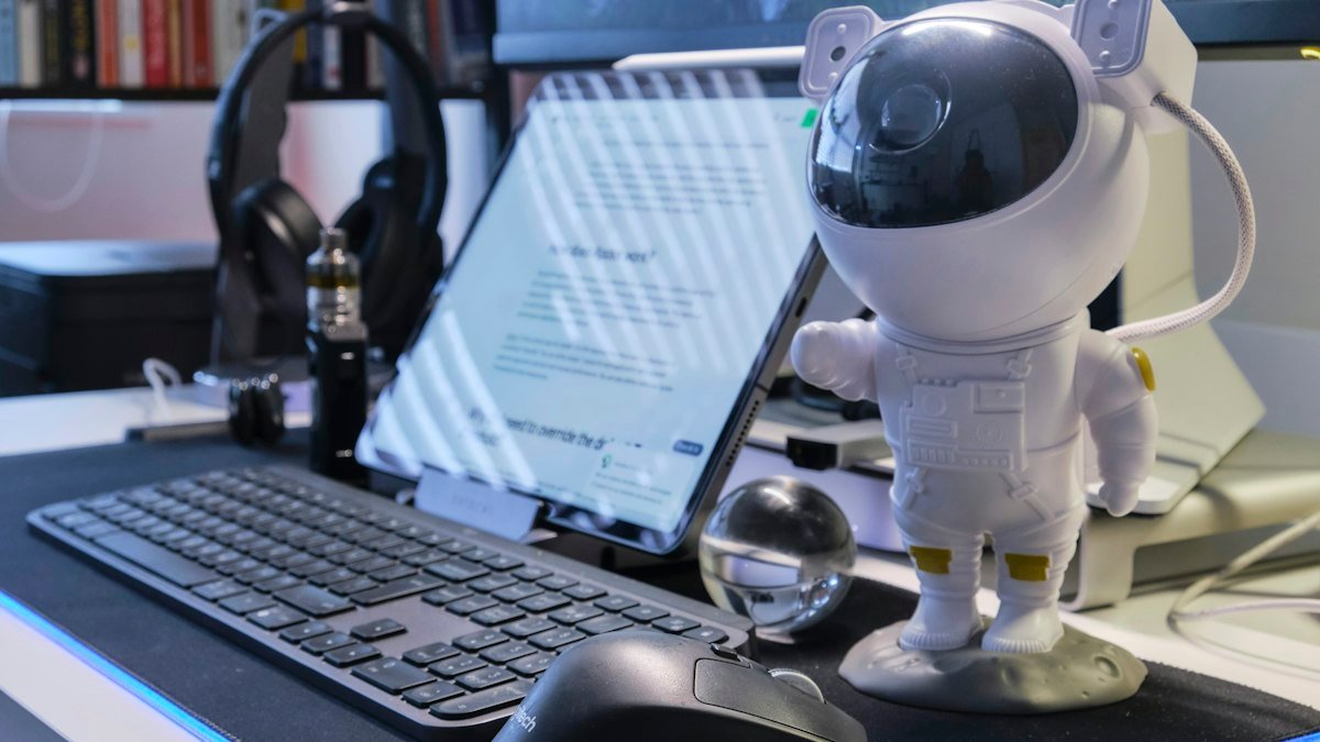 Ilustração sobre o que é um agente de IA: robô ao lado de um notebook em uma mesa de trabalho